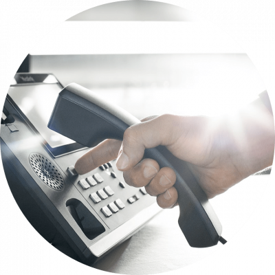 Hand, die einen Telefonhörer hält und eine Nummer wählt