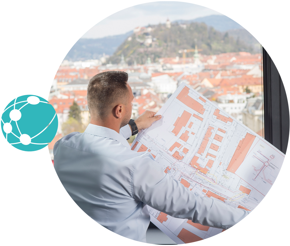 Mitarbeiter, der einen Stadtplan ansieht und vor einem Fenster mit Blick auf den Grazer Schlossberg steht und das Network Icon seitlich